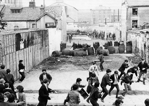 Youth running away from British troops in the Bogside area of Derry